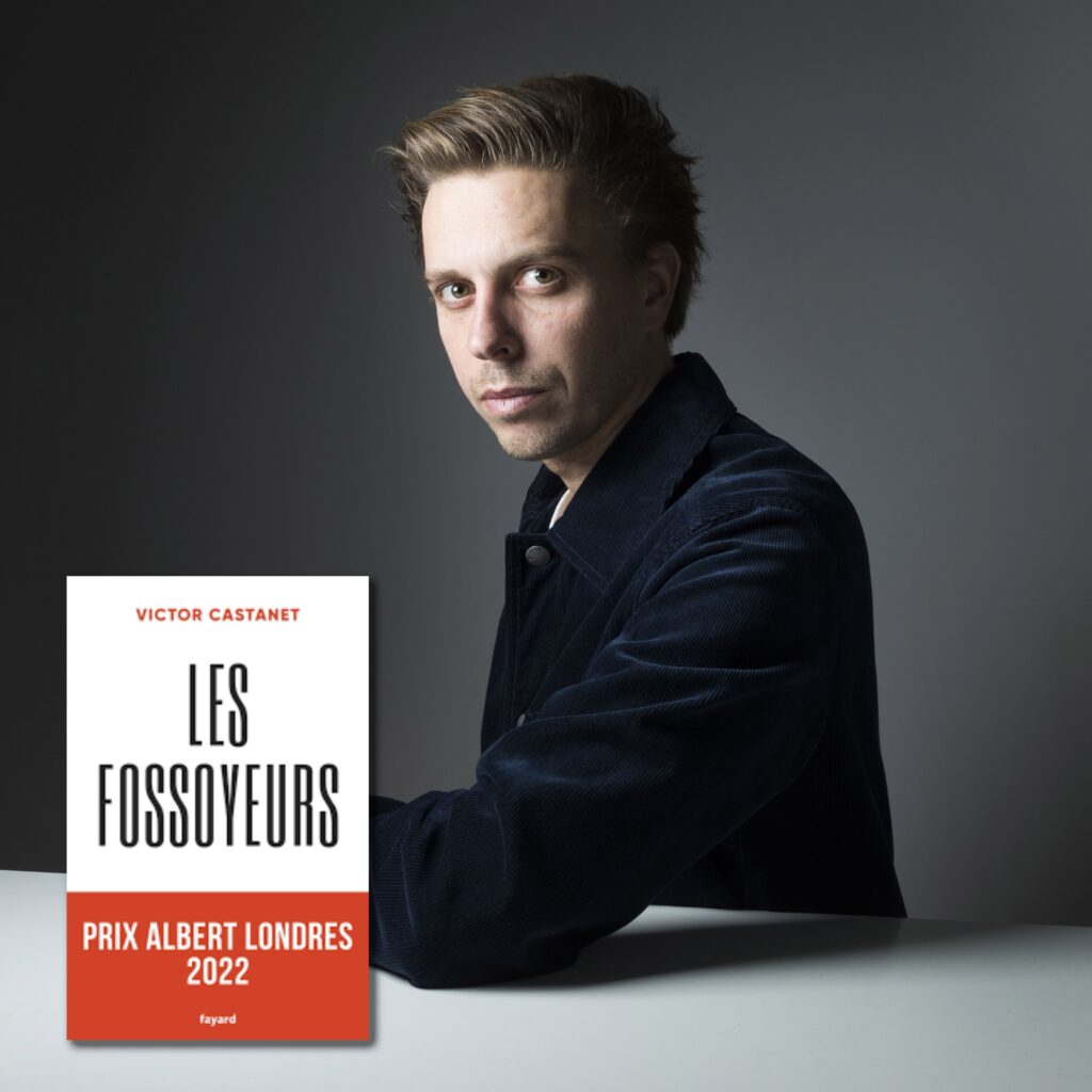 Portrait professionnel en studio de Victor Castanet, journaliste d'investigation, posant en veste noire sur fond gris. À ses côtés, la couverture de son livre 'Les Fossoyeurs' publié chez Fayard, qui a reçu le Prix Albert Londres 2022.